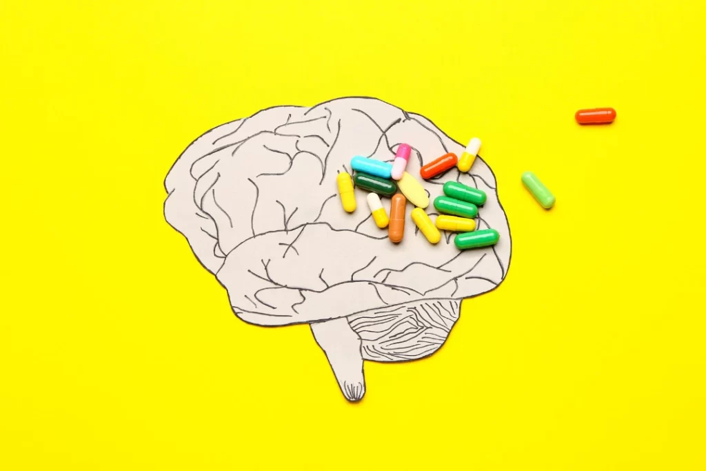 Brain diagram with pills on it with yellow background