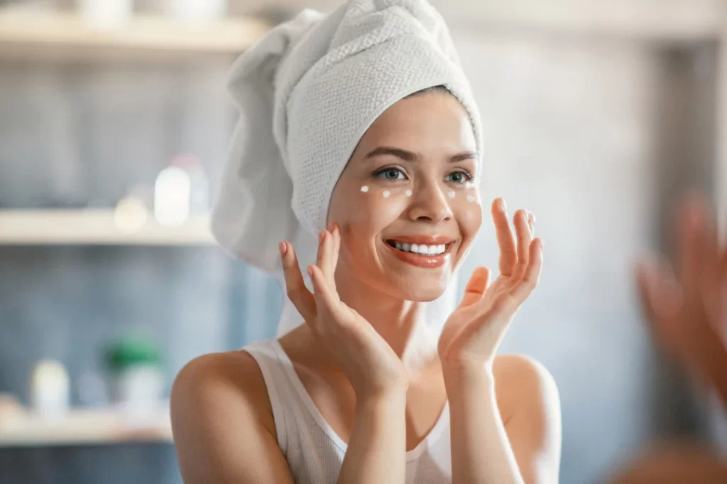 Woman enjoying tighter and younger skin while applying anti-wrinkle cream.