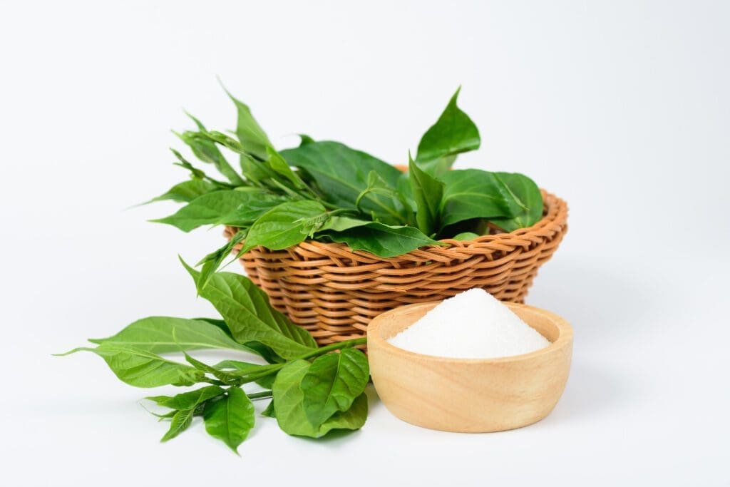 Fresh Gymnema Sylvestre leaves in a wooden basket with the sugar bowl. 