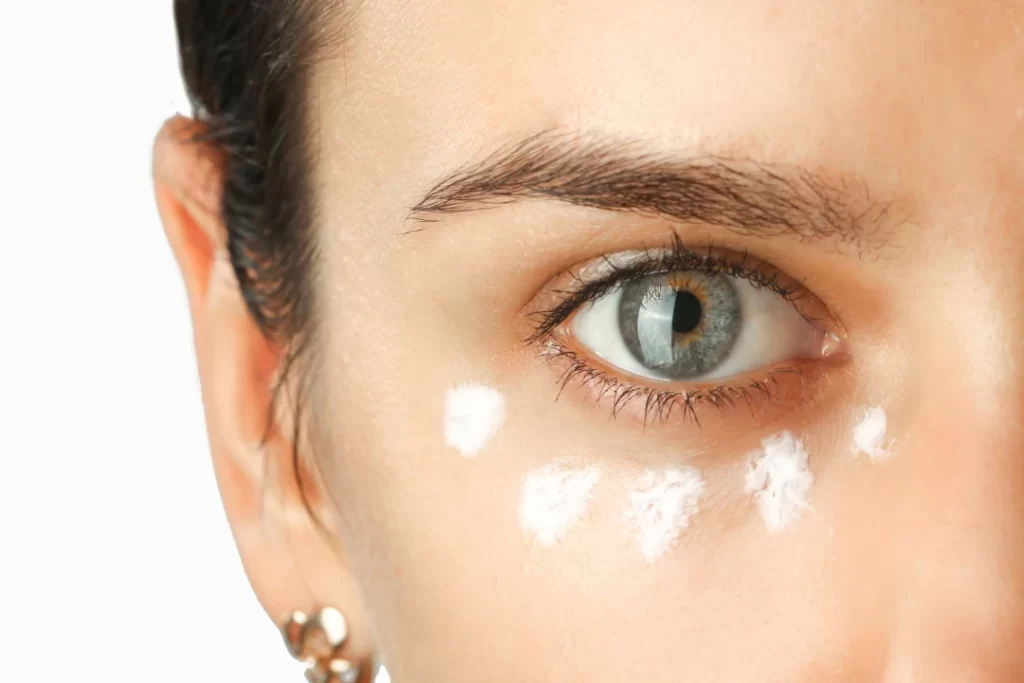 Woman applying eye wrinkled cream. 
