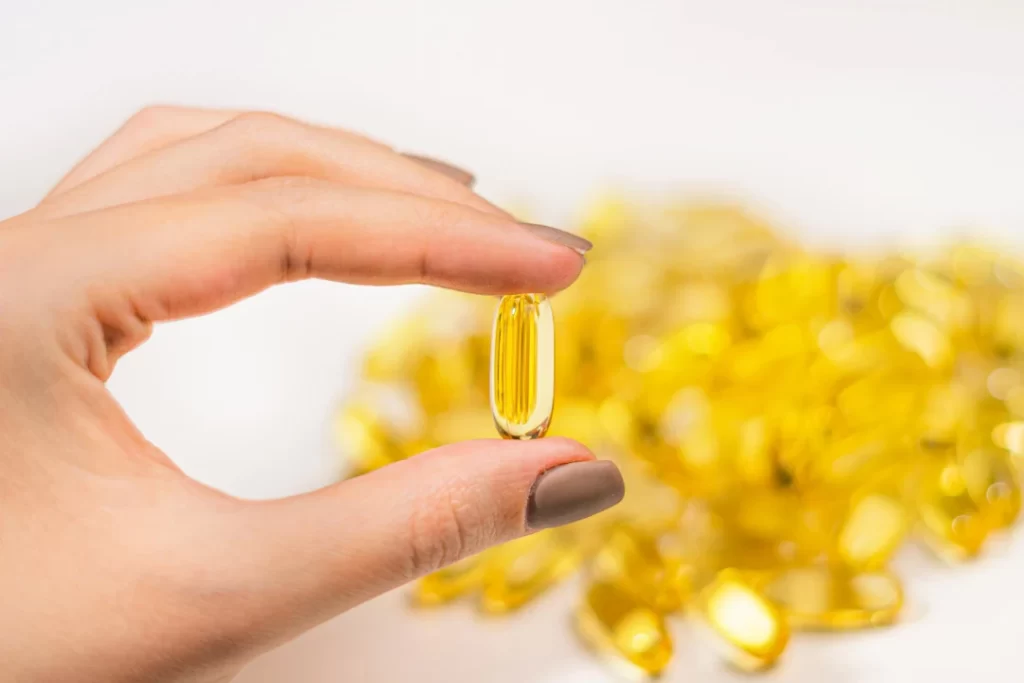 Omega 3 Fish oil pills in woman hand.