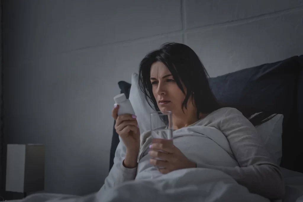 woman with sleep disorder holding glass of water