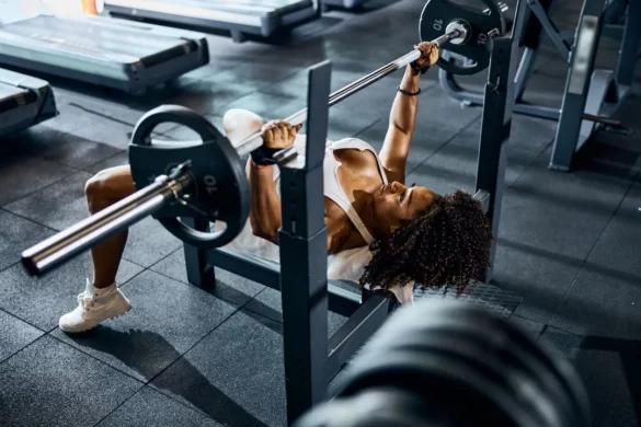 Fit woman bench pressing at gym.