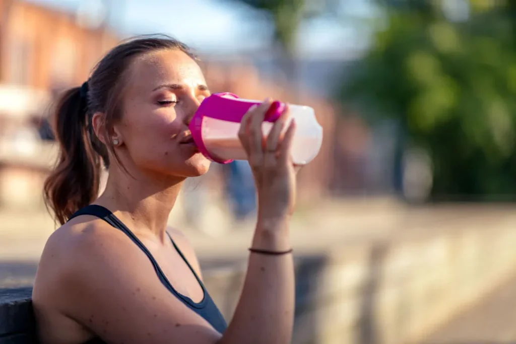 A lady drinking protein shake.  