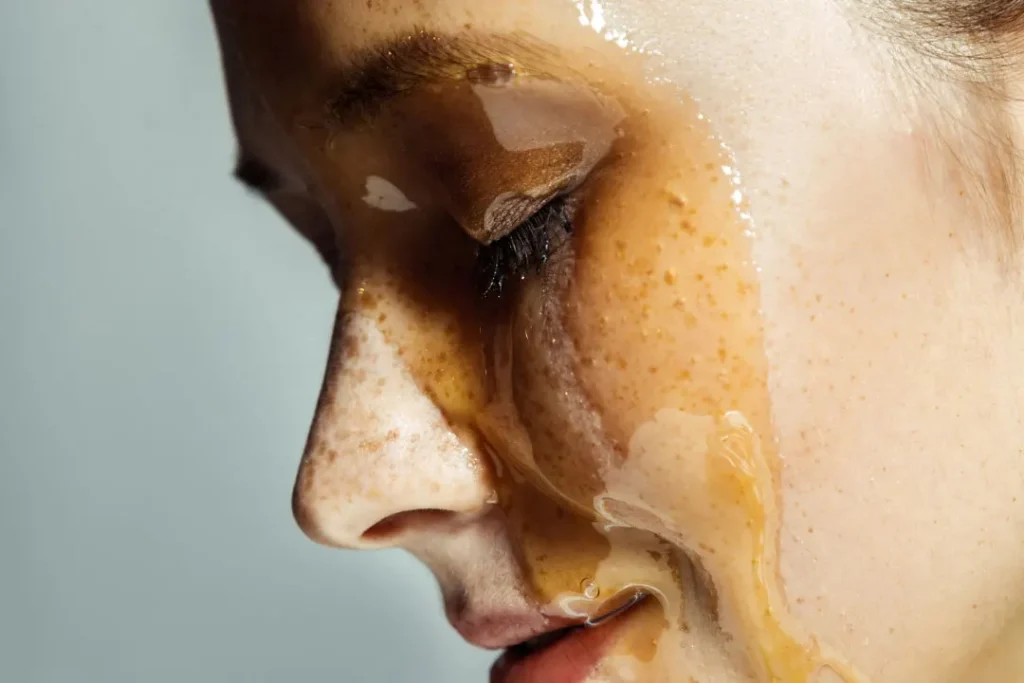 Face of lady covered with honey.