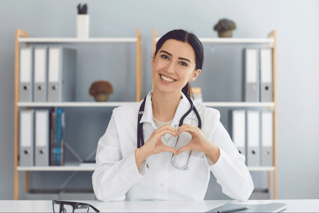 Female doctor showing heart protection model with her hands.